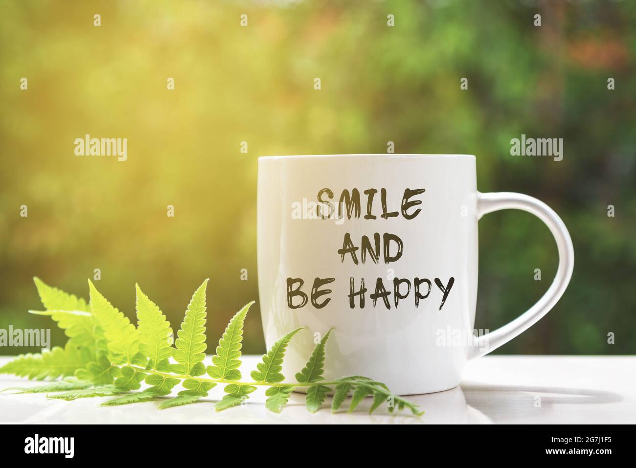 Lächeln und glücklich sein inspirierende Zitate auf Kaffeebecher Stockfoto