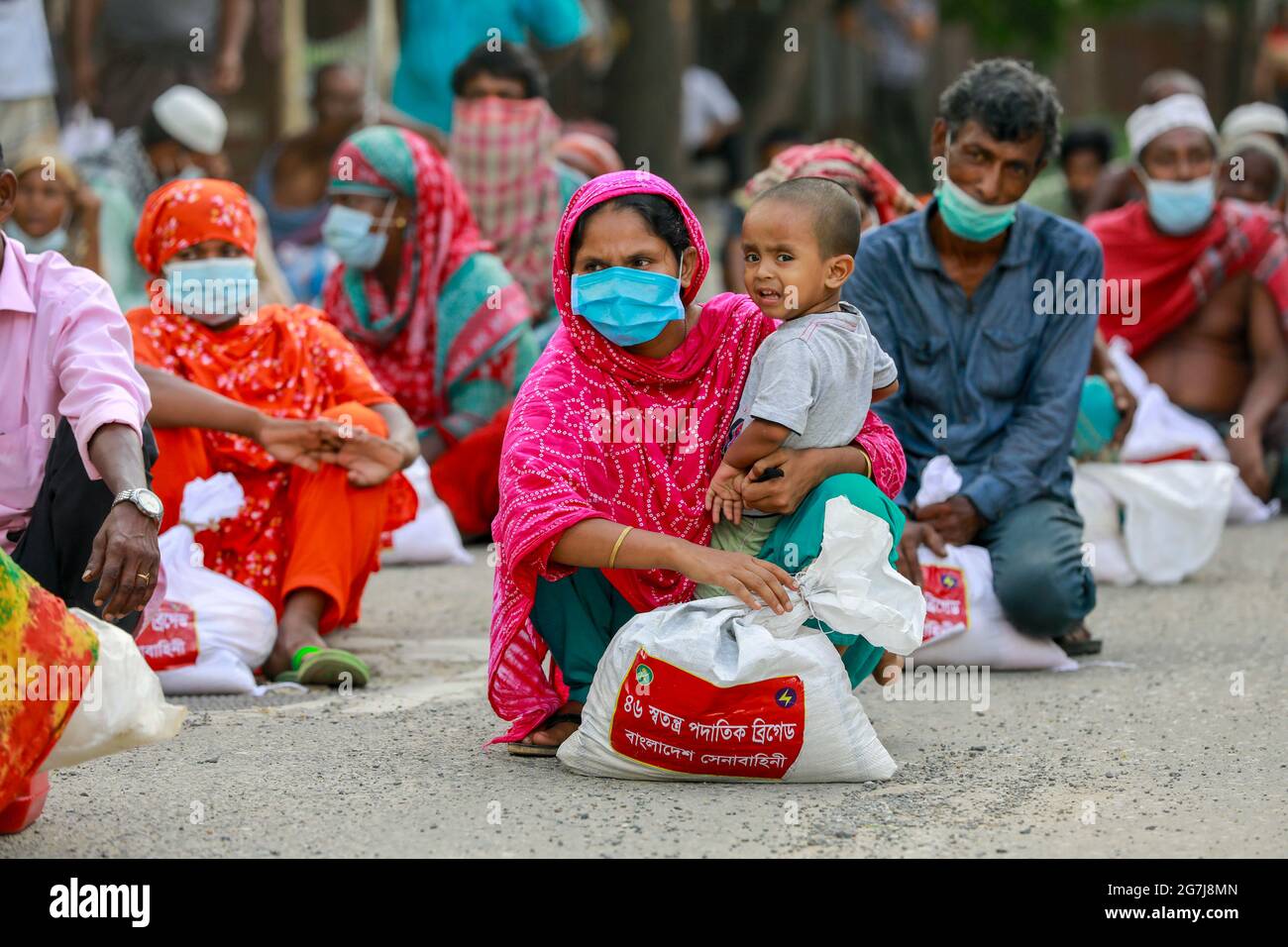 Dhaka, Bangladesch. Juli 2021. Menschen mit niedrigem Einkommen erhalten während der landesweiten Sperre zur Eindämmung der Ausbreitung des Coronavirus (COVID-19) in Dhaka, Bangladesch, 14. Juli 2021, Nahrungsmittel, die von der Armee von Bangladesch zur Verfügung gestellt werden. Quelle: Suvra Kanti das/ZUMA Wire/Alamy Live News Stockfoto