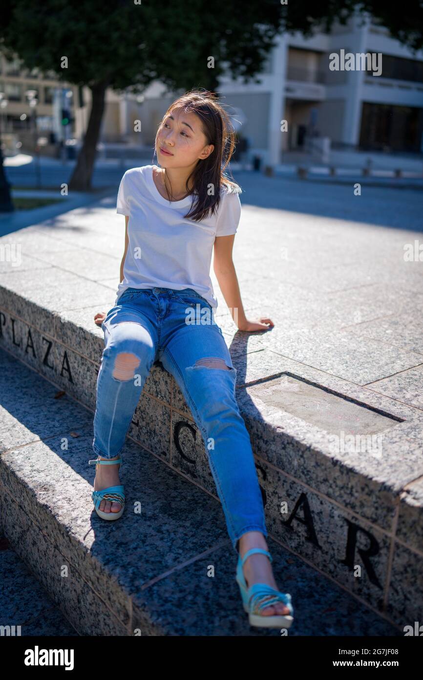 Junge asiatische Frau sitzt auf der Treppe in der Innenstadt Plaza Stockfoto
