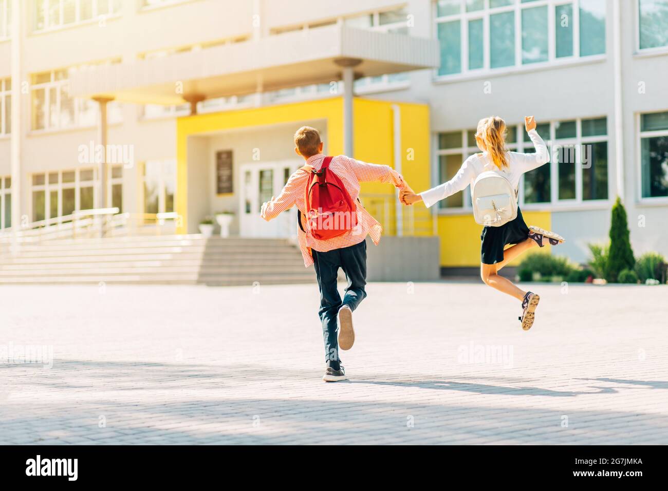 Schüler in Uniform Junge und Mädchen, die mit Schulrucksäcken zur Schule gehen, Schüler auf dem Weg zur Schule, für Kinder lernen Stockfoto