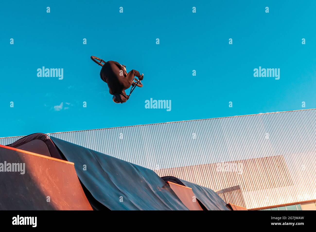 BMX-Fahrer macht Trick auf Rampe im Skatepark. Sport, Extremsport, Freestyle, das Konzept der Outdoor-Aktivität. Stockfoto