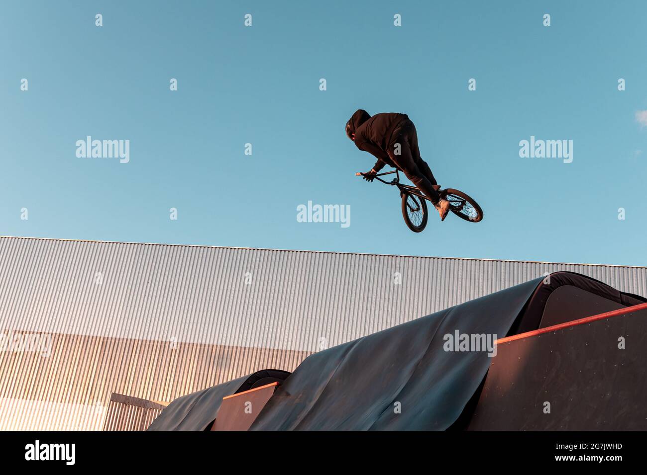 BMX-Fahrer macht Trick auf Rampe im Skatepark. Sport, Extremsport, Freestyle, das Konzept der Outdoor-Aktivität. Stockfoto