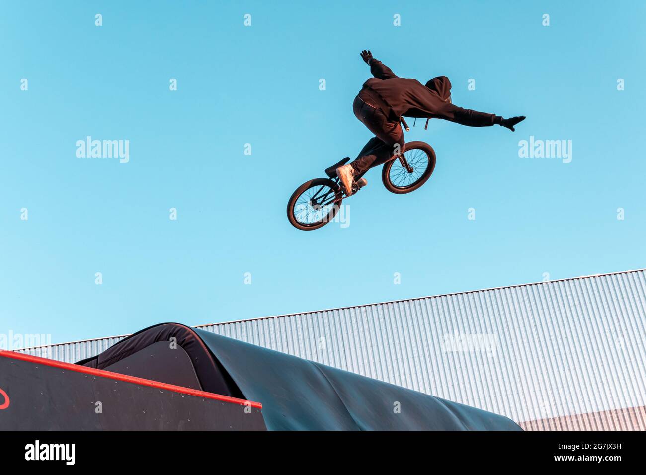 BMX-Fahrer macht Trick auf Rampe im Skatepark. Sport, Extremsport, Freestyle, das Konzept der Outdoor-Aktivität. Stockfoto