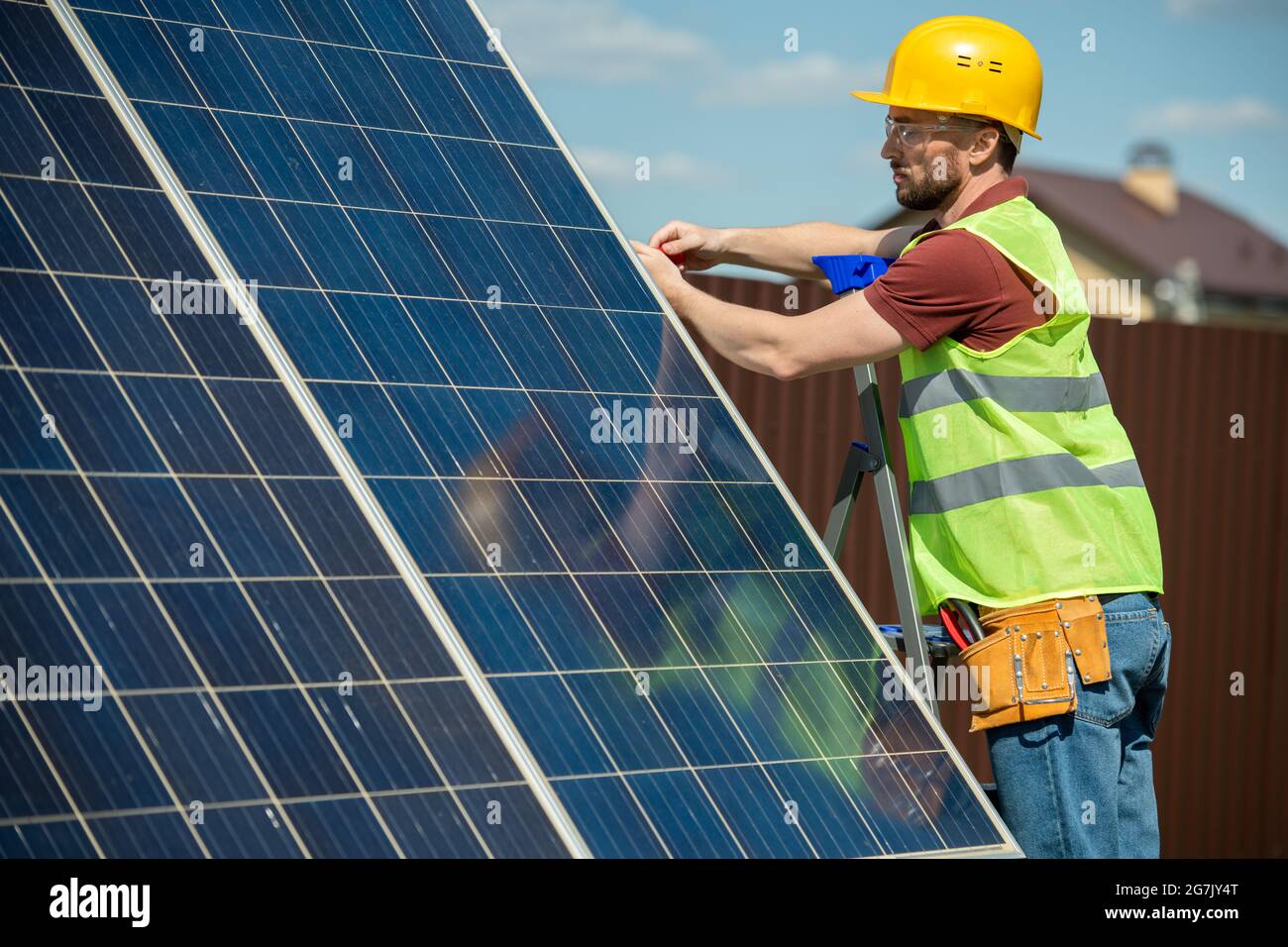 Serious Engineer Installation von Solarmodulen, die helfen, Stromrechnungen, Abhängigkeit von ausländischem Öl und fossilen Brennstoffen zu reduzieren Stockfoto