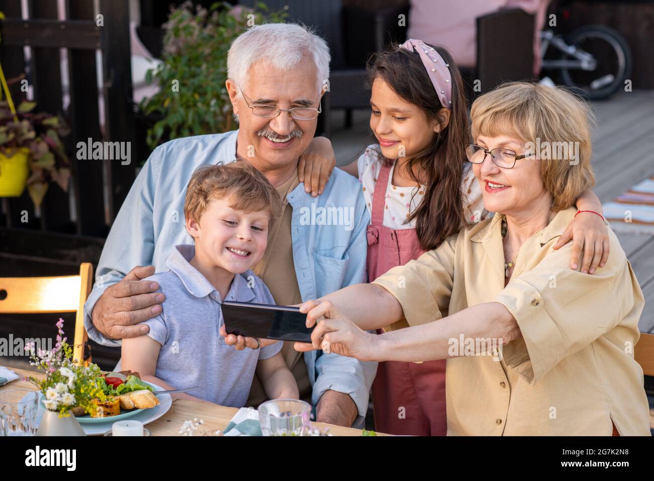 Glückliche Großeltern und Enkelkinder, die beim Familientreffen gemeinsam Selfie machen Stockfoto