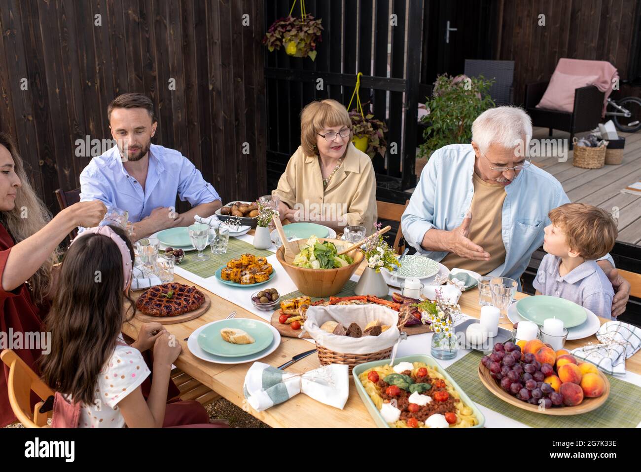 Großvater im Gespräch mit dem kleinen Enkel beim Familientreffen Abendessen Stockfoto