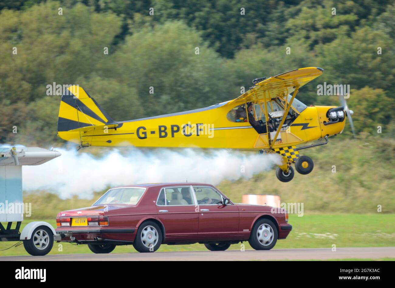 O'Brien's Flying Circus Kunstflug Stunt Team Trailer Top Landing Stunt bei Shoreham Airshow. Vintage Piper J-3C-65 Cub Plane. Anhänger mit dem Auto abgeschleppt Stockfoto