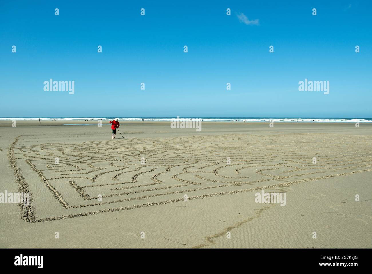 Mann, der ein Strandlabyrinth in Cannon Beach, Oregon, macht Stockfoto