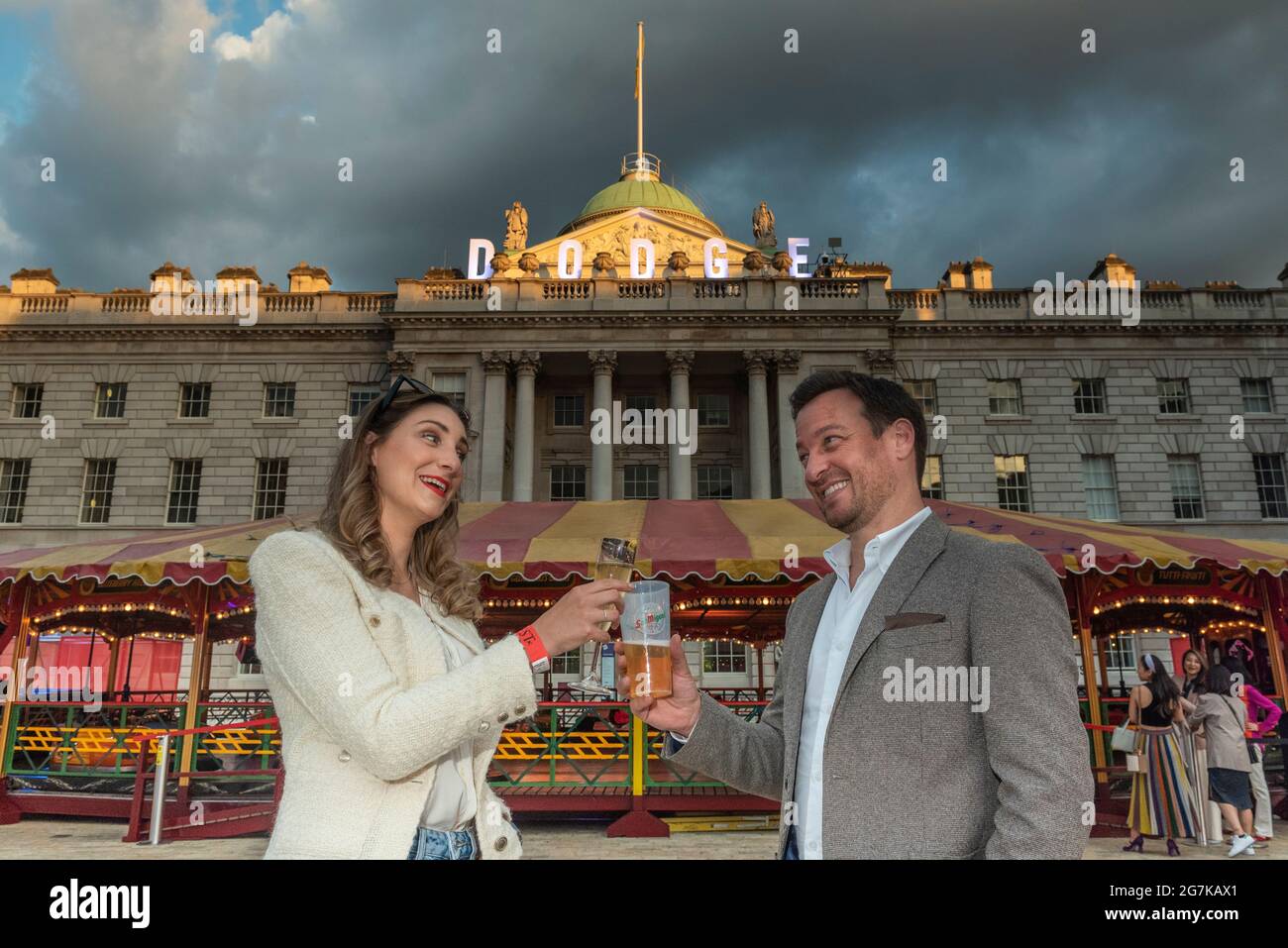 London, Großbritannien. 14. Juli 2021. Besucher von DODGE, einer großen Dodgem-Autofahrt, im Innenhof des Somerset House. Der Raum wurde von Yinka Ilori, einer der gefragtesten Gestalten im Design, neu gestaltet und in ein fröhliches Spektakel aus Farbe, Klang und Energie für den Sommer verwandelt. Die Fahrt sowie die gesellschaftlich distanzierten Speisen- und Getränkepads in der Nähe sind vom 15. Juli bis 22. August für die Öffentlichkeit zugänglich. Kredit: Stephen Chung / Alamy Live Nachrichten Stockfoto