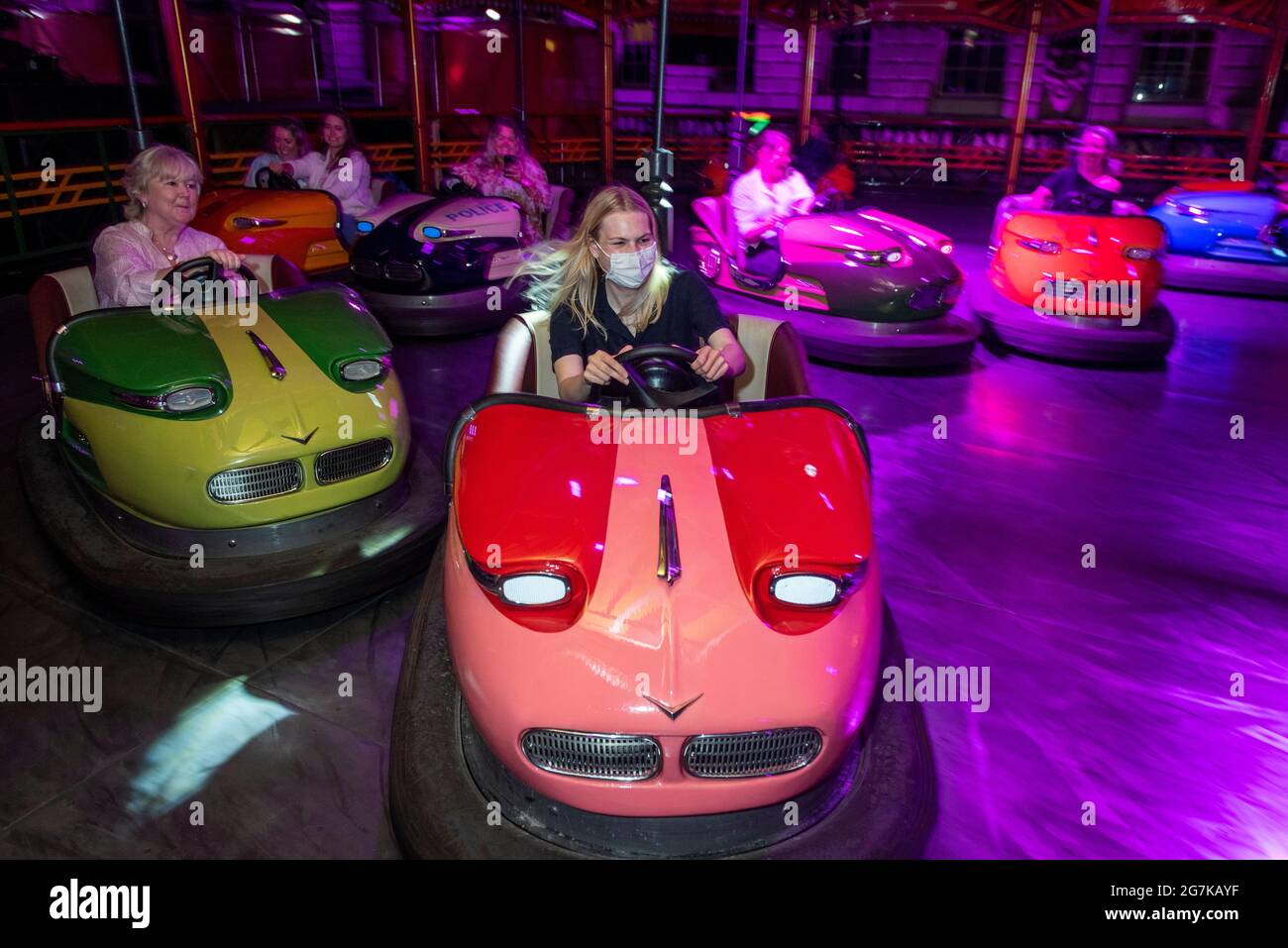 London, Großbritannien. 14. Juli 2021. Die Leute fahren auf DER DODGE, einer großen Dodgem-Autofahrt, die im Innenhof des Somerset House eingerichtet ist. Der Raum wurde von Yinka Ilori, einer der gefragtesten Gestalten im Design, neu gestaltet und in ein fröhliches Spektakel aus Farbe, Klang und Energie für den Sommer verwandelt. Die Fahrt sowie die gesellschaftlich distanzierten Speisen- und Getränkepads in der Nähe sind vom 15. Juli bis 22. August für die Öffentlichkeit zugänglich. Kredit: Stephen Chung / Alamy Live Nachrichten Stockfoto