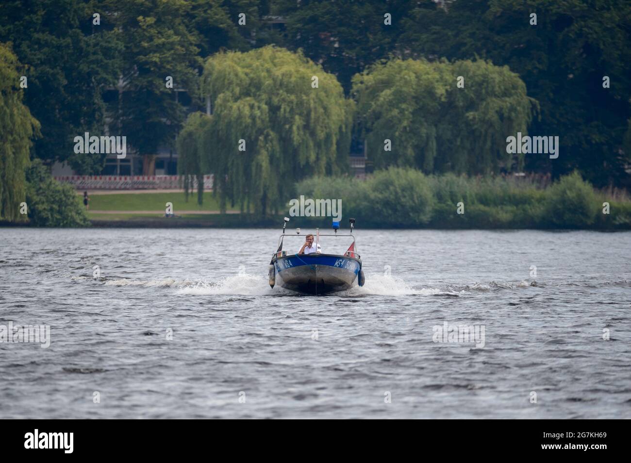 Hamburg, Deutschland. Juli 2021. Vater Schwan Olaf Nieß segelt sein Boot auf der Außenalster. Die Hamburger Alster-Schwäne haben endlich Nachwuchs bekommen. Quelle: Jonas Walzberg/dpa/Alamy Live News Stockfoto