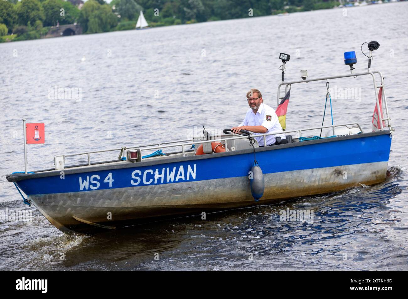 Hamburg, Deutschland. Juli 2021. Vater Schwan Olaf Nieß segelt sein Boot auf der Außenalster. Die Hamburger Alster-Schwäne haben endlich Nachwuchs bekommen. Quelle: Jonas Walzberg/dpa/Alamy Live News Stockfoto