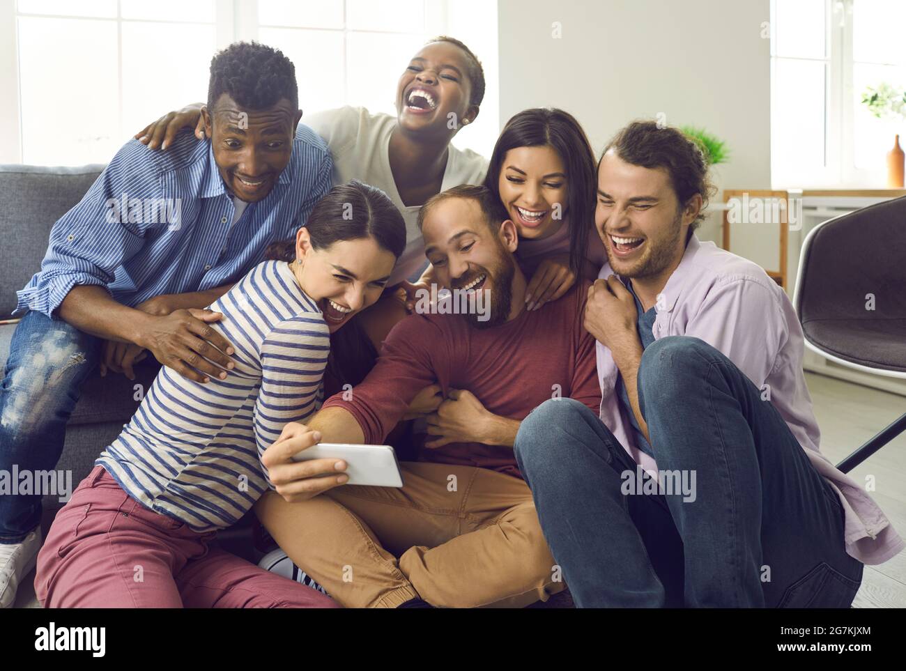 Fröhliche multirassische Freunde haben Spaß und machen Selfies während freundlicher Treffen zu Hause. Stockfoto