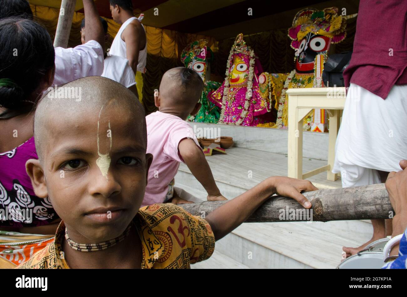 Ein Kind, das an einem glückverheißenden Nachmittag auf der Ratha yatra (Chariot Pulling) von Lord Jagannath in Mayapur, Indien, eifrig Anhänger ist. Stockfoto