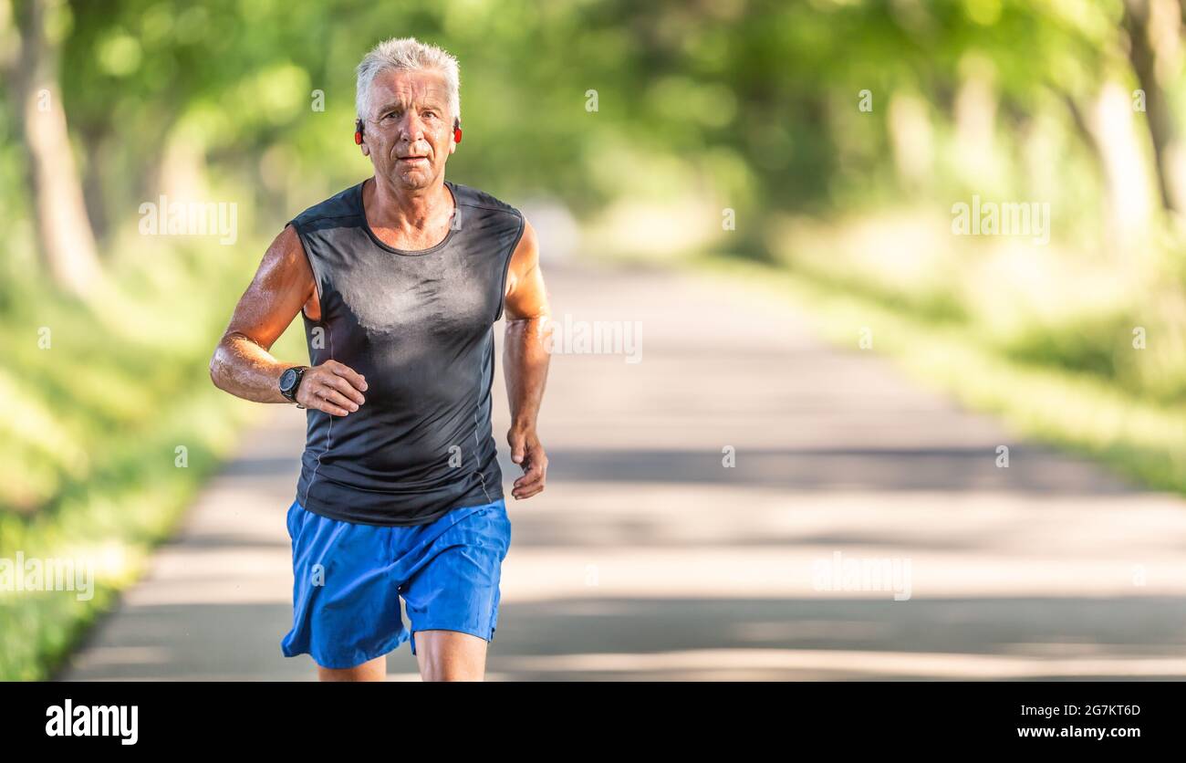 Fit alten Mann in Shorts und Hemd ohne Ärmel läuft im Freien in der Natur. Stockfoto