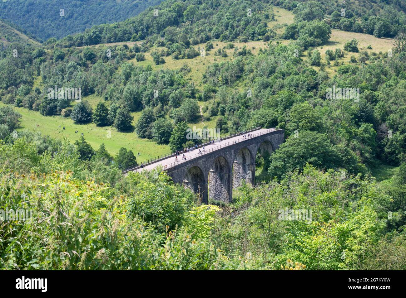 Radfahrer und Wanderer überqueren den Grabstein-Viadukt (Monsal Viaduct), einen Teil des Monsal Trail, von Monsal Head aus gesehen, in der Nähe von Bakewell, Derbyshire, England, Großbritannien Stockfoto
