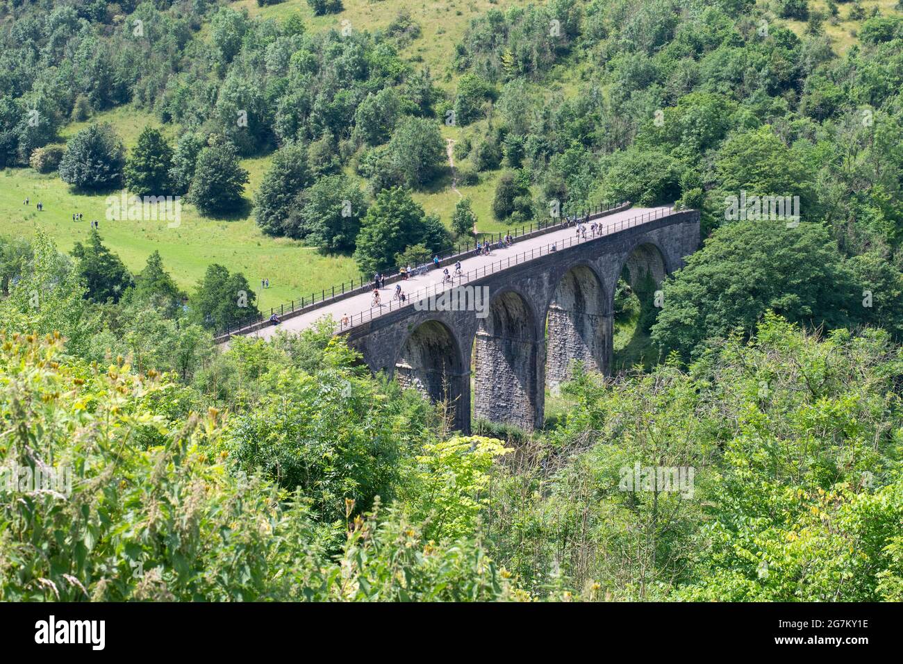 Radfahrer und Wanderer überqueren den Grabstein-Viadukt (Monsal Viaduct), einen Teil des Monsal Trail, von Monsal Head aus gesehen, in der Nähe von Bakewell, Derbyshire, England, Großbritannien Stockfoto