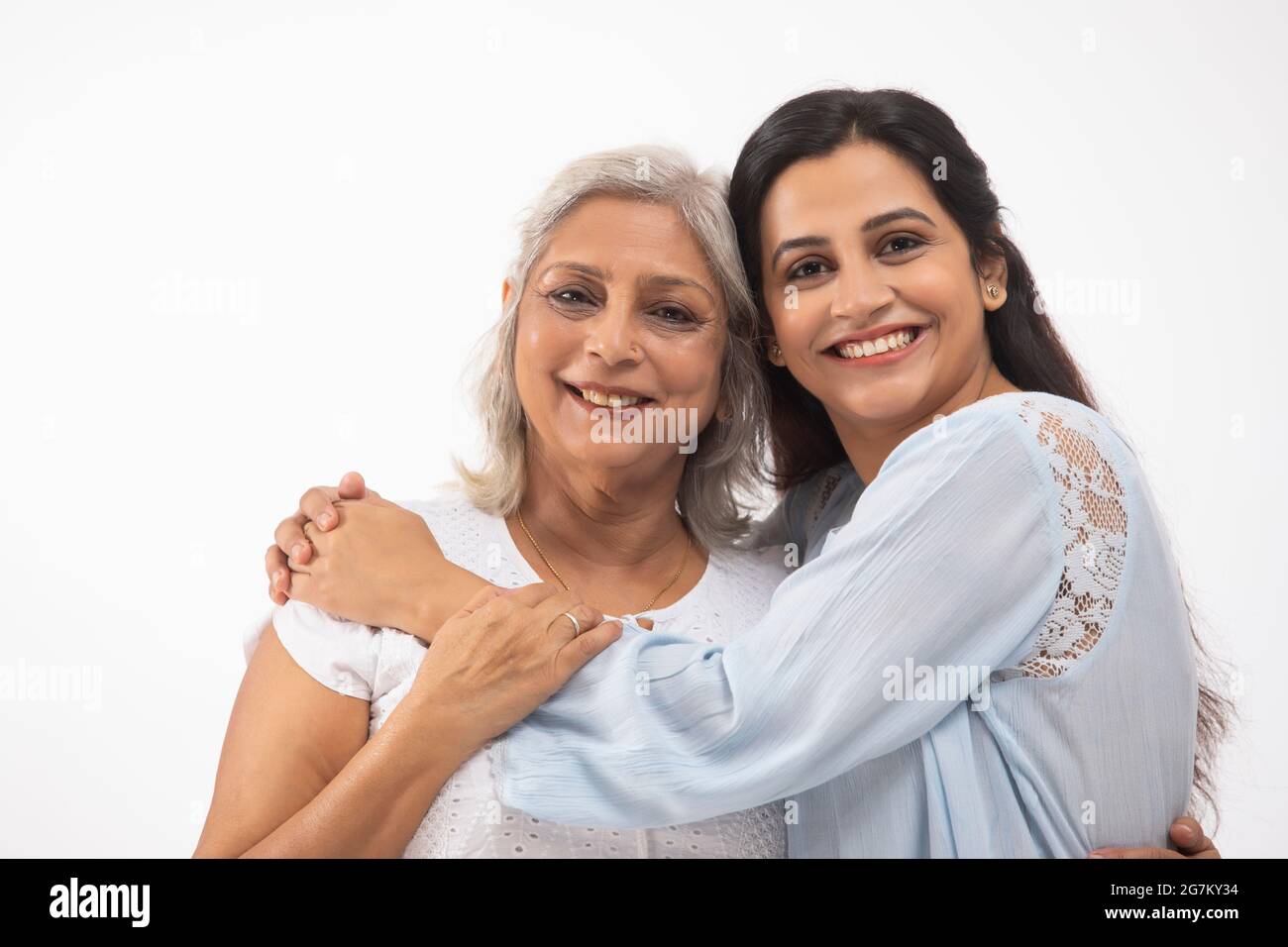 EINE JUNGE FRAU UND IHRE MUTTER POSIEREN GEMEINSAM VOR DER KAMERA Stockfoto