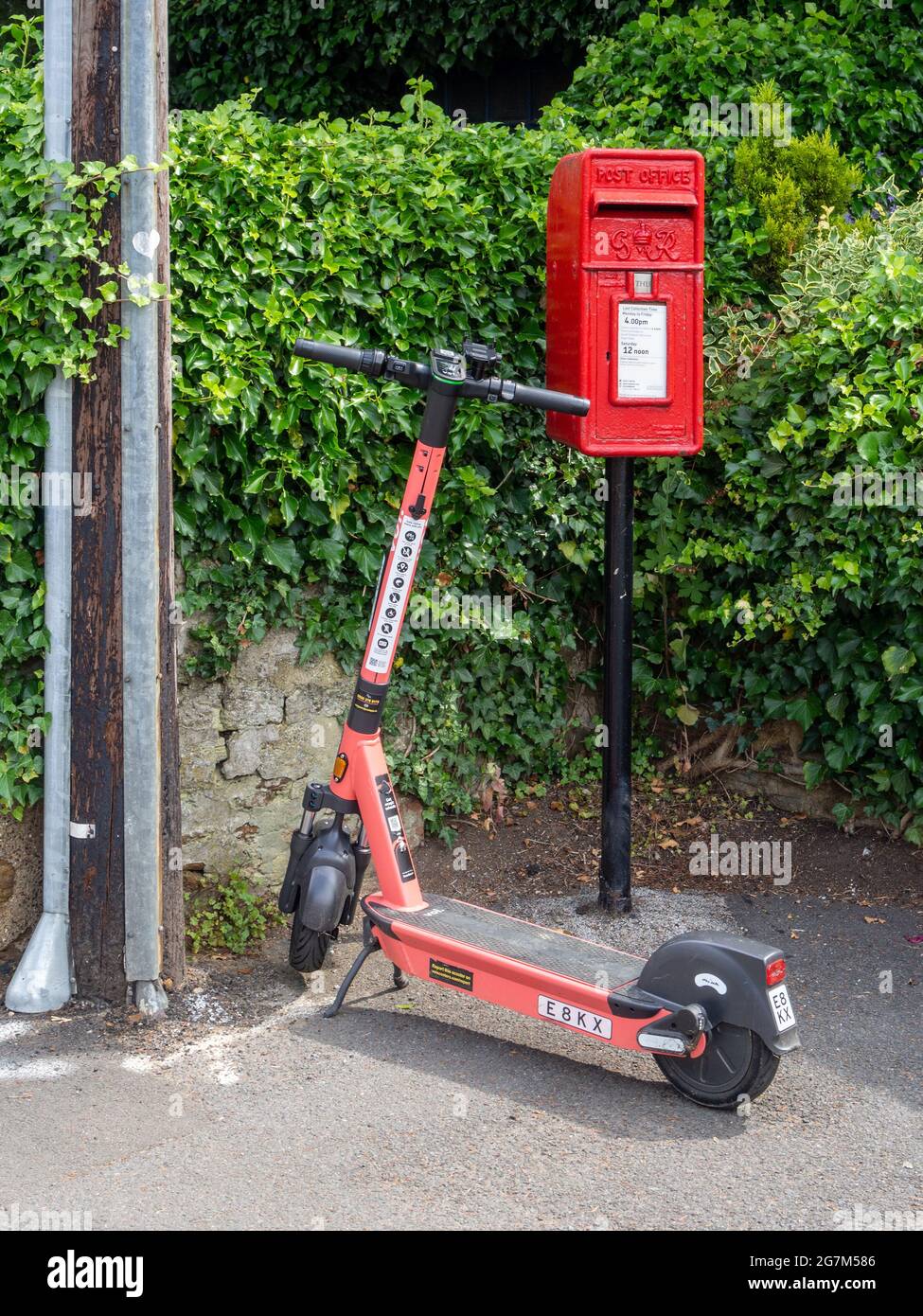 VOI E-Scooter, neben einem Briefkasten, Northampton, Großbritannien; Teil eines vom gemeinderat initiierten Prozesses zur Förderung alternativer Transportmittel. Stockfoto