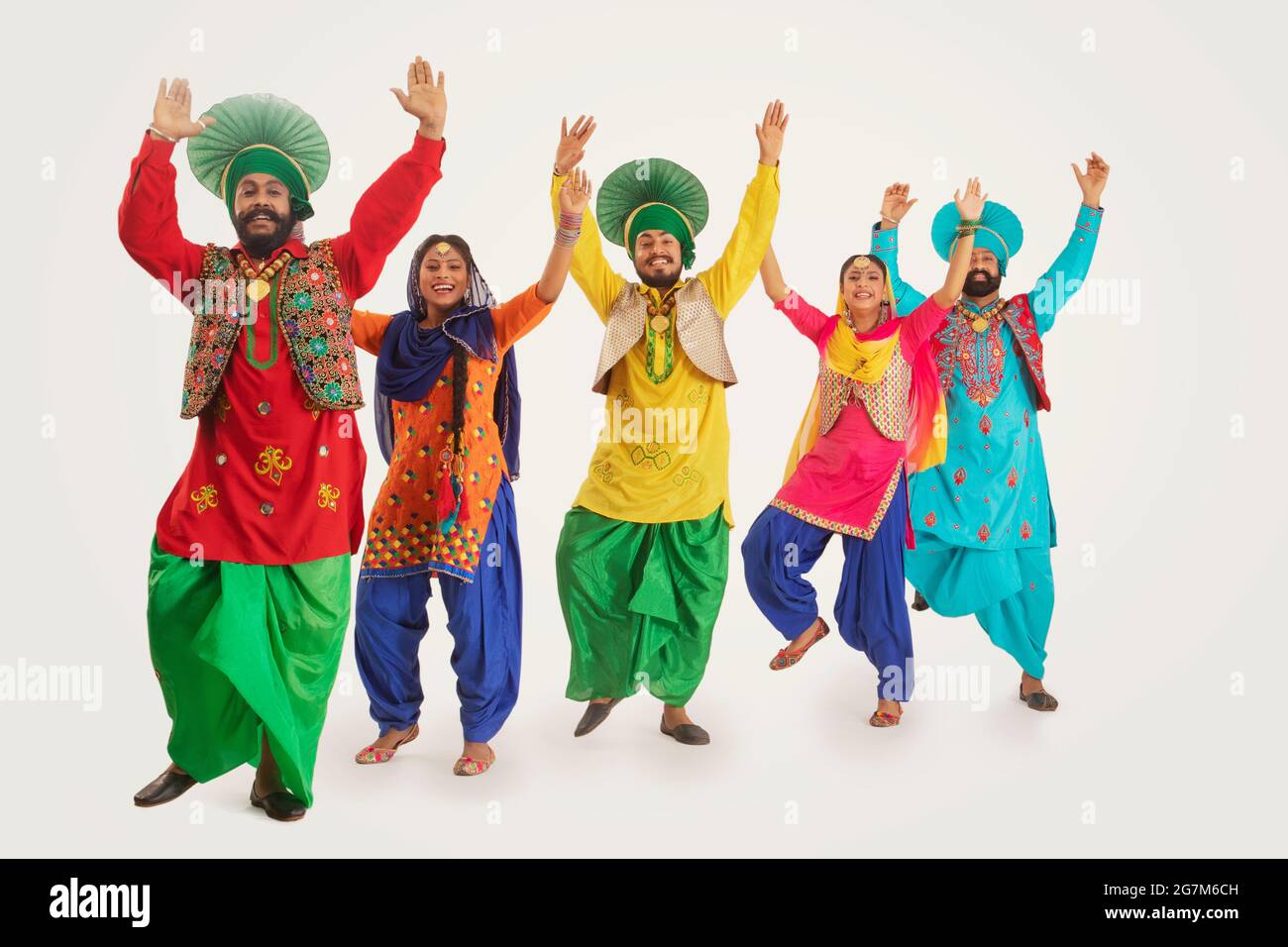 Eine Gruppe von Punjabi Folk-Tänzern, die einen Tanzschritt mit den Händen in der Luft durchführen. Stockfoto