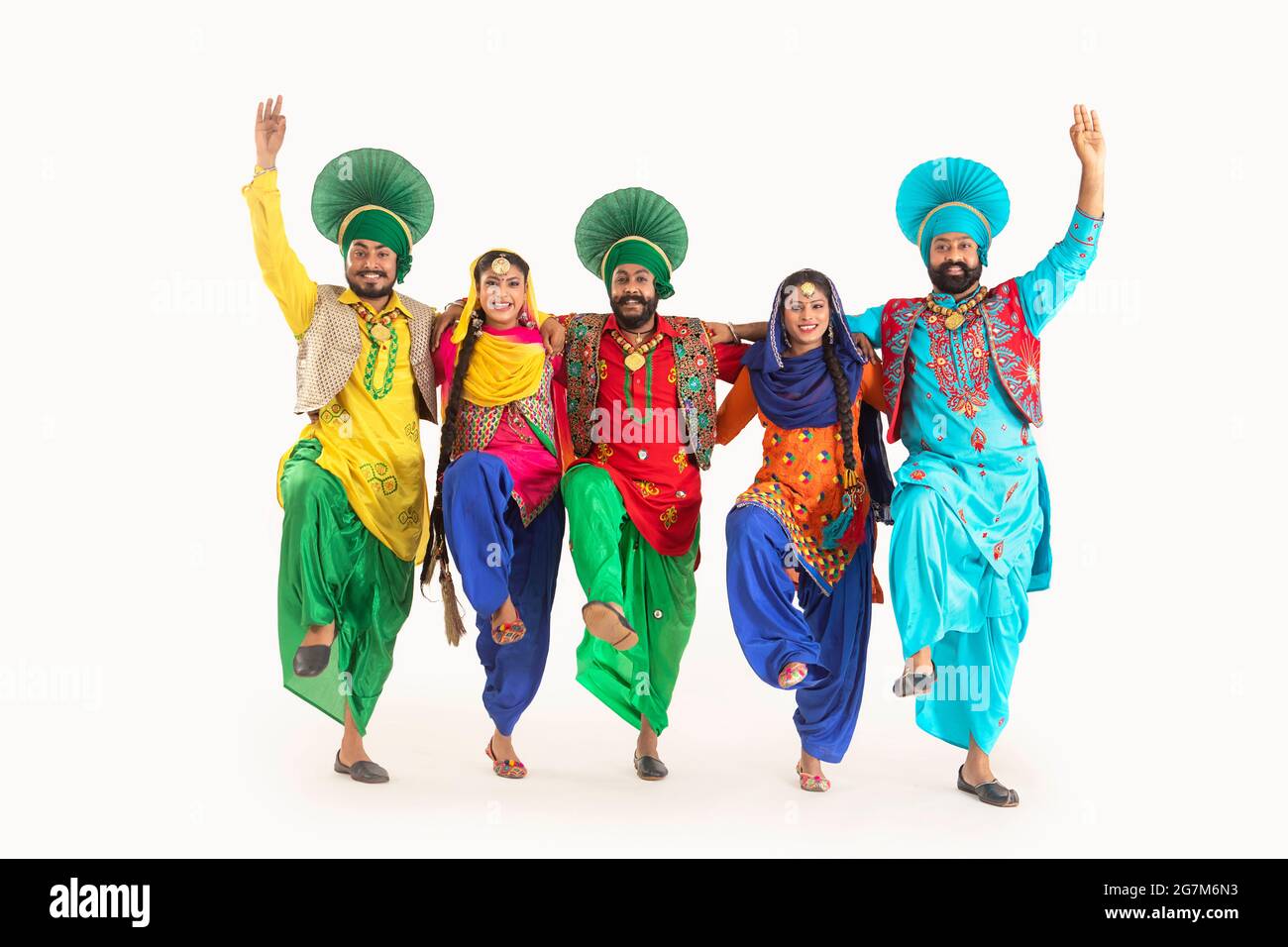 Eine Truppe von Punjabi Folk-Tänzern, die in Kostümen gekleidet sind und gemeinsam einen Tanzschritt machen. Stockfoto