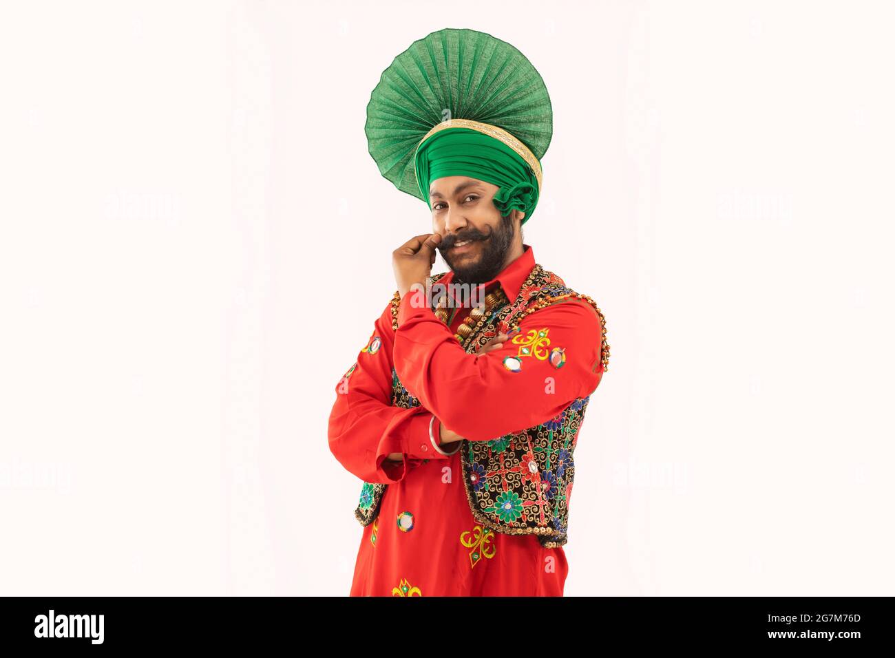 Ein Mann in einem Bhangra-Kostüm streichelte seinen Bart. Stockfoto