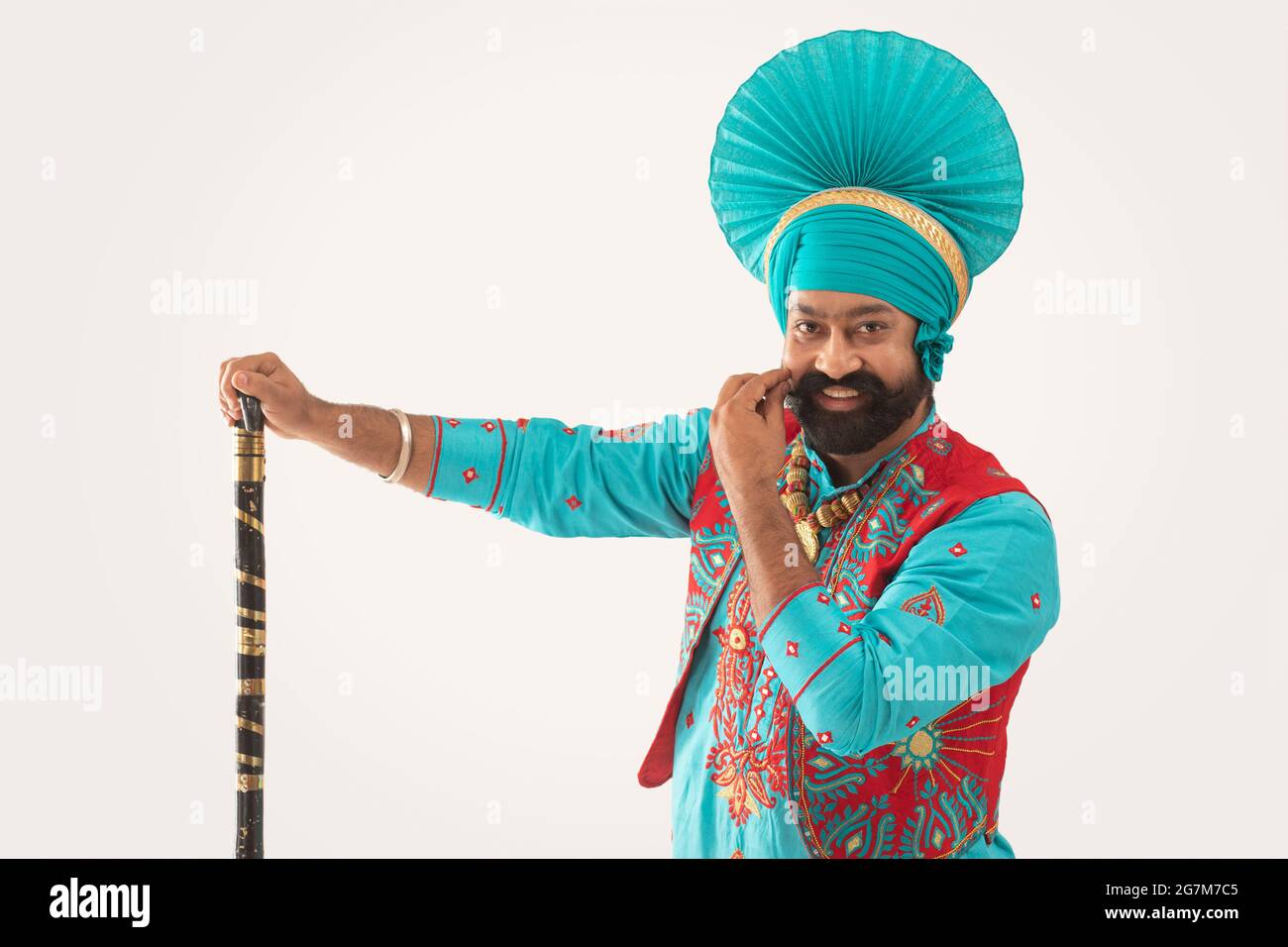 Ein Bhangra-Tänzer streichelte seinen Bart mit einer Khunda in der Hand. Stockfoto