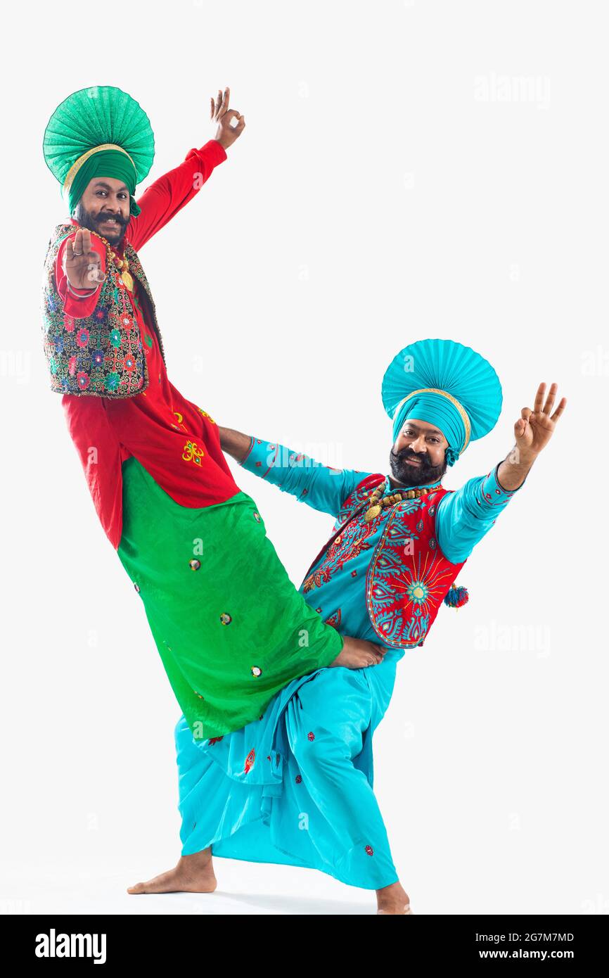 Zwei Bhangra-Tänzer schlagen einen klassischen Schritt ihrer Tanzform ein. Stockfoto