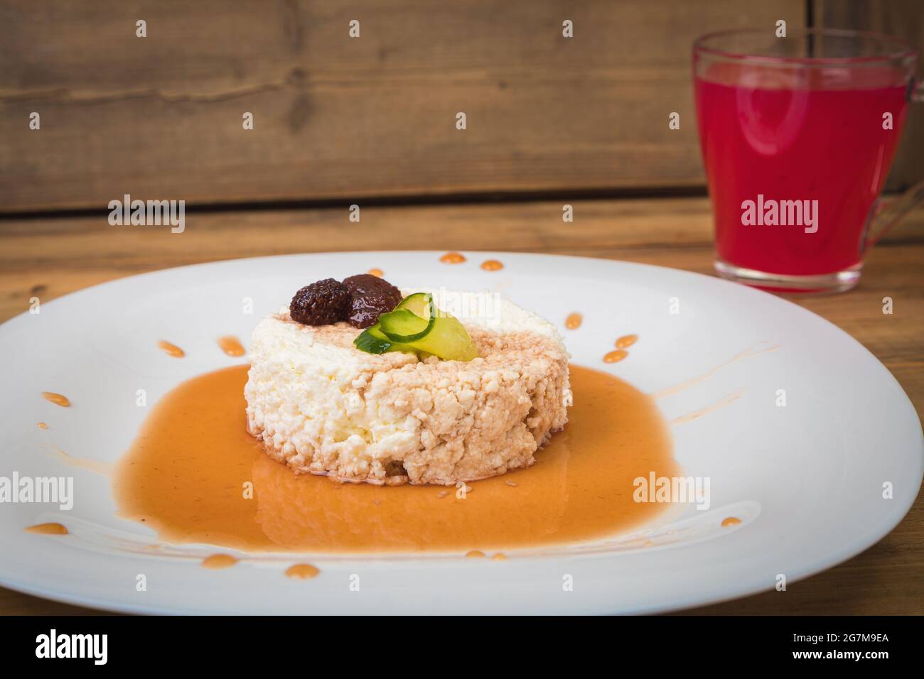 Frühstück Hüttenkäse mit Marmelade auf einem weißen Teller mit einer Tasse Gelee. Nahaufnahme. Stockfoto