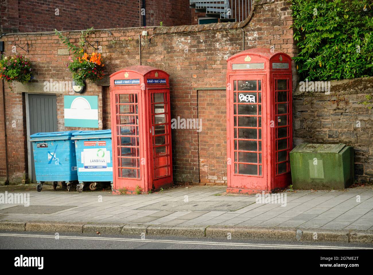 Ein paar alte verblasste rote Telefonzellen in Exeter, Devon. Stockfoto