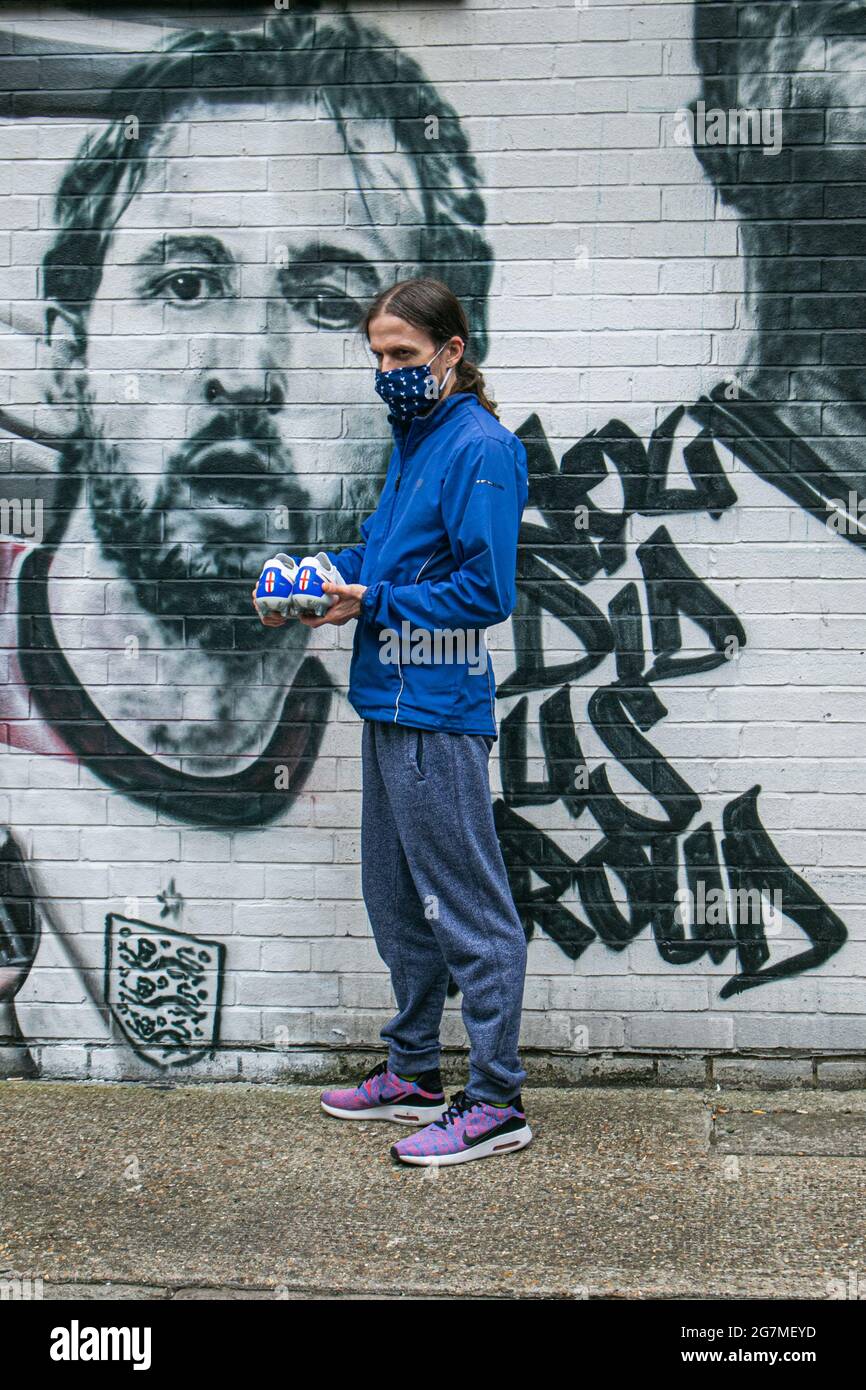 LONDON 15 Juli 2021 . Fußballfan Nick Herbert posiert mit den von dir auf Nike entworfenen Harry Kane Schuhen vor dem Wandbild, das im Auftrag des Londoner Bürgermeisters Sadiq Khan in Essig Yard in der Nähe der London Bridge von dem städtischen Straßenkünstler MurWalls enthüllt wurde. Das Wandbild zeigt ein Bild von Manager Gareth Southgate, Kapitän Harry Kane und Raheem Sterling „You did US stolze“ und würdigt die Erfolge der englischen Fußballmannschaft beim Erreichen des Finales der Fußball-Europameisterschaft 2020. Credit amer Ghazzal/Alamy Live News Stockfoto
