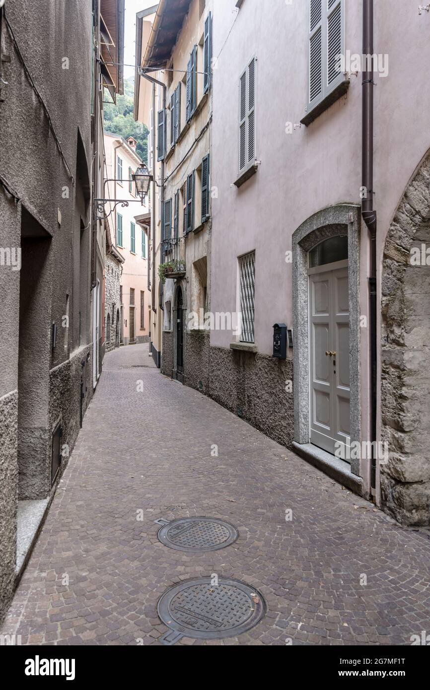 Malerisches Stadtbild mit alten Häusern auf der sich biegenden Straße in einem Dorf am Seeufer, aufgenommen im Sommer in Torno, Como, Italien Stockfoto