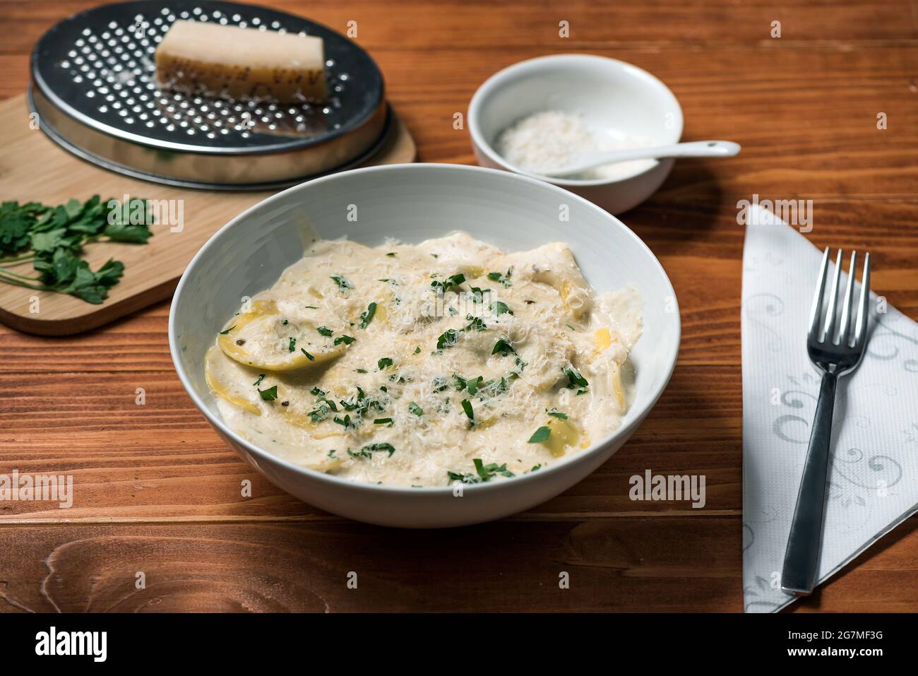 Ravioli mit Pilzen, Parmigiano, Petersilie und frischem Basilikum. Holztisch-Anordnung. Nahaufnahme Stockfoto