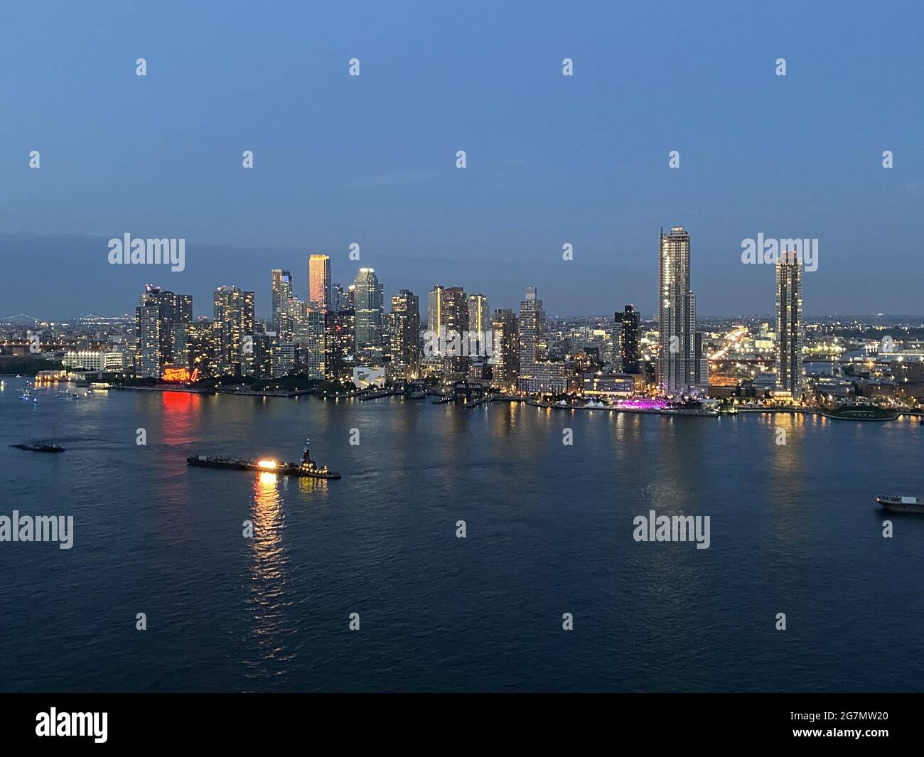 Blick über den East River von der 34th Street in Manhattan an der Queens Shoreline auf. Julhy 4. 2021. Auf den im Fluss zu sehenden Lastkähne wird nach Einbruch der Dunkelheit das Annullierungsfeuerwerk der Macy gestartet. Stockfoto