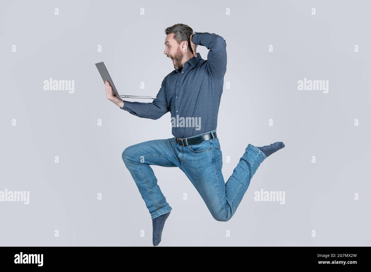 Überrascht energischer Mann springen während der Arbeit online auf Laptop Beeilen Sie sich zum Einkaufen, Überraschung. Stockfoto