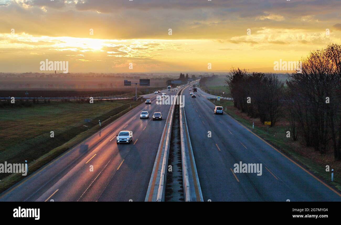 Highway Transport mit Autos bei Sonnenuntergang Verkehr Stockfoto