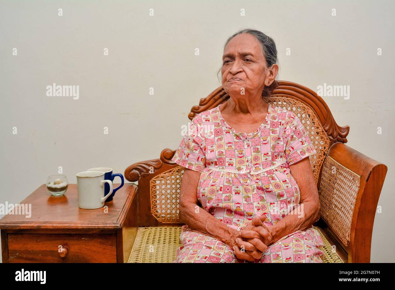 Eine asiatische Großmutter (alte Frauen) im Porträt auf einem Stuhl Stockfoto