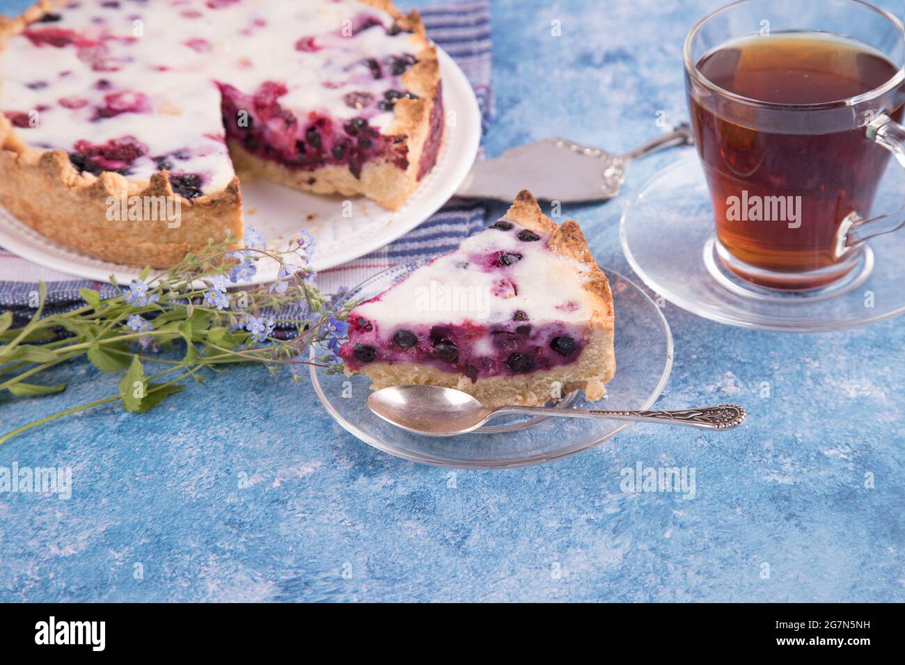 Hausgemachte Kuchen mit einer Torte mit Beerenfüllung und einer Tasse Tee. Stockfoto