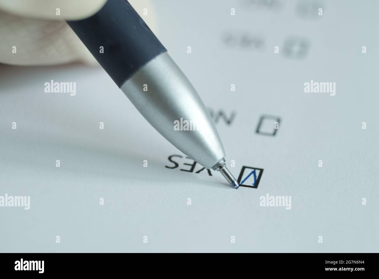 Ein weißes Blatt des Fragebogens, die Antwort 'ja' wird mit einem Stift gesetzt. Verschwommenes Bild. Stockfoto