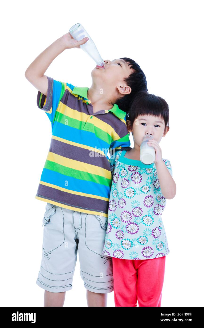 Asiatische Kinder halten eine Flasche Milch. Milch trinken für eine gute Gesundheit. Junge und Mädchen trinken Milch und umarmen sich zusammen, auf weißem Hintergrund. Studio-Sho Stockfoto