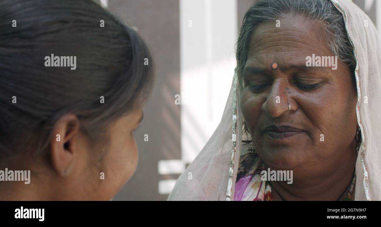 Ältere Frau aus Indien, die einer schönen jungen Inderin Ratschläge gibt Stockfoto