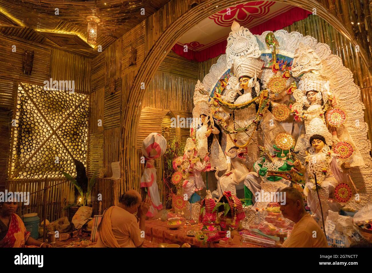 KOLKATA , INDIEN - 27. SEPTEMBER 2017 : Hindu-Priester verehrt Göttin Durga, während Dhaakis (Trommler) in seinem Rücken auftreten. Durga Puja Festival Stockfoto