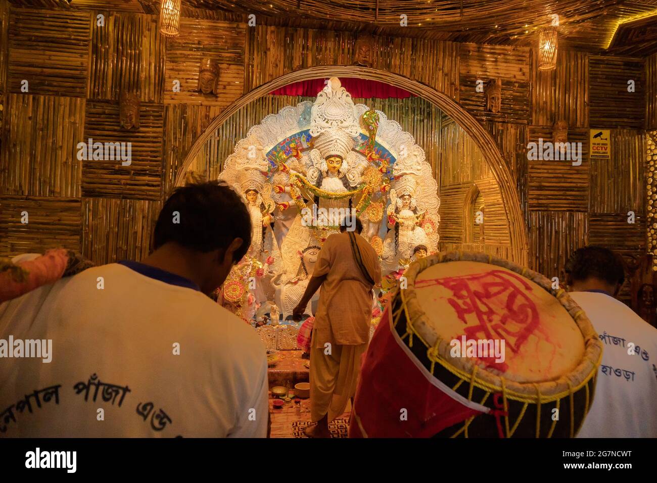 KOLKATA , INDIEN - 27. SEPTEMBER 2017 : Hindu-Priester verehrt Göttin Durga, während Dhaakis (Trommler) in seinem Rücken auftreten. Durga Puja Festival Stockfoto