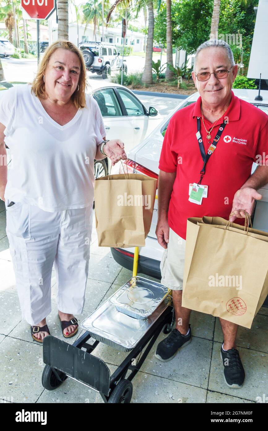 Florida Miami Surfside Red Cross Freiwillige Hispanic Mann Frau liefern Mahlzeiten Essen Champlain Towers South Condo Condominium buildi Stockfoto