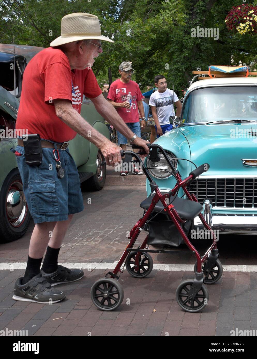 Ein älterer Mann mit Rollator oder Rollschuh besucht eine Oldtimer-Show vom 4. Juli in Santa Fe, New Mexico. Stockfoto