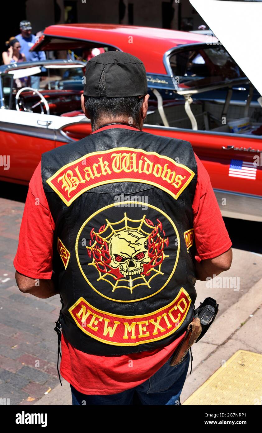 Ein Mann in einem Motorradschläger-Leder trägt eine mit einem Holsterband beladene Pistole in der Öffentlichkeit auf einer Oldtimer-Show am 4. Juli in Santa Fe, New Mexico. Stockfoto