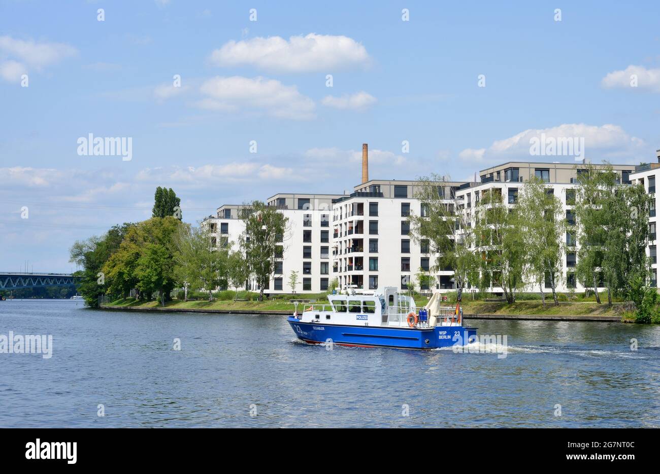 Berlin, Deutschland, ein Patrouillenboot der Wasserpolizei, das an der Spree vorbeifährt und neue Wohnhäuser baut Stockfoto