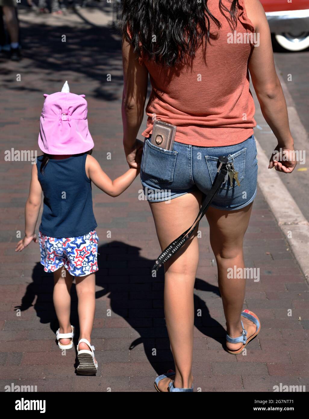 Eine Frau geht Hand in Hand mit ihrer jungen Tochter auf einer Autoausstellung in Santa Fe, New Mexico. Stockfoto