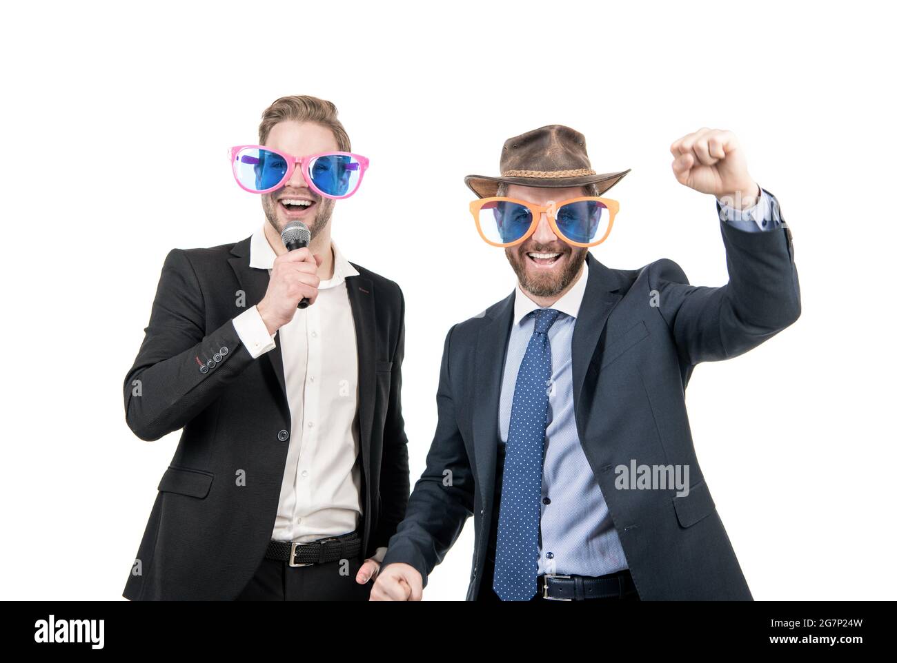 Glückliche Mitarbeiter haben Spaß, Karaoke in lustigen Brillen und formalwear singen, Firmenfeier Stockfoto