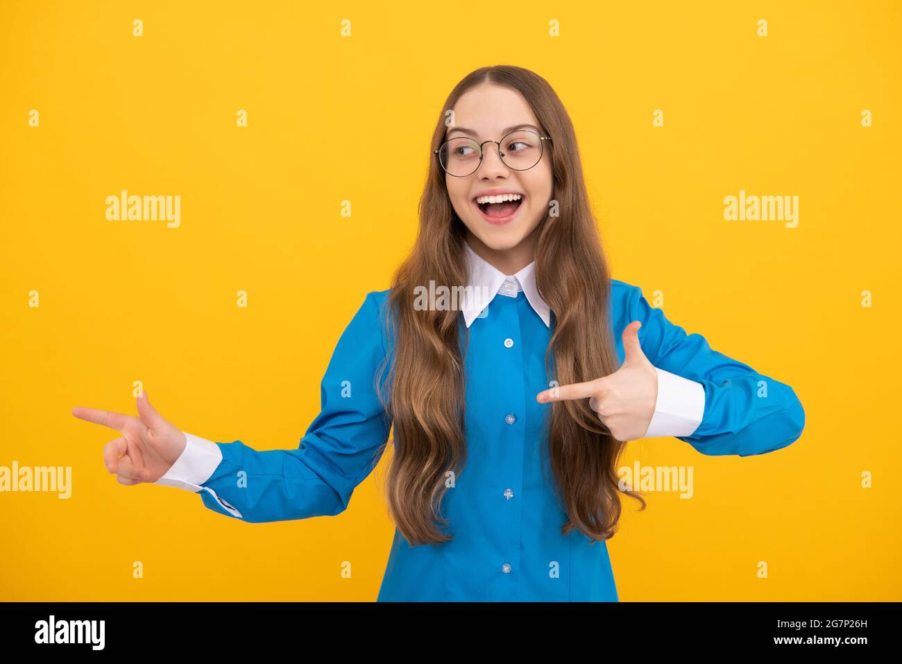 Glücklich zurück zur Schule Kind zeigen Finger für die Werbung gelben Hintergrund Kopie Raum, zeigen Stockfoto
